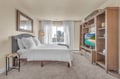 Relax in your stylish bedroom with plush bedding, entertainment center, and bright windows overlooking the peaceful neighborhood.