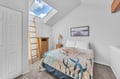 Rest peacefully under your private skylight, where natural light floods this cozy bedroom and blue skies peek through above.