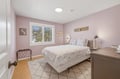 Unwind in your serene bedroom with soft pink walls, crisp linens, and natural light streaming through the window, creating a peaceful retreat for restful nights.