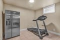 Your private basement fitness area features a treadmill and extra refrigerator, perfect for staying active and storing refreshments during your stay.
