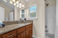 Your private bathroom features beautiful granite countertops, warm wood cabinetry, and bright vanity lighting for your morning routine.