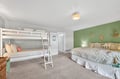 Gather your crew in this cheerful bedroom where bunk beds and a queen bed create the perfect family retreat with coastal charm.