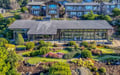 Stunning contemporary property features extensive landscaped gardens with putting greens and walking paths in a prestigious hillside neighborhood.
