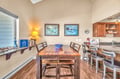 Gather around the solid wood dining table for memorable meals with ocean artwork creating a coastal ambiance in your dining space.