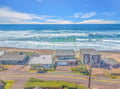 Stunning beachfront property sits directly on pristine sandy shores with endless ocean views and rolling waves.