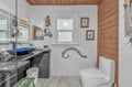 Refresh in your stylish bathroom featuring a sleek glass shower, modern vessel sink, and warm wood ceiling details.