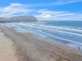 Pristine sandy shoreline meets rolling waves beneath dramatic coastal bluffs and endless blue skies.