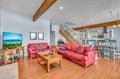 Relax in your spacious living area with exposed wooden beams, red leather seating, and open views to the kitchen.