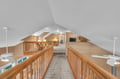 Your cozy loft retreat features warm wood railings, comfortable seating areas, and charming sloped ceilings that create an intimate hideaway.