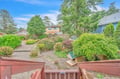 A private garden with mature trees and landscaped shrubs, set in a peaceful neighborhood near the coast.