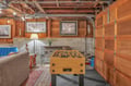 Unwind in your cozy basement game room with comfortable seating and fun foosball table, perfect for entertaining evenings.
