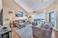 Your coastal retreat awaits with plush seating and stunning ocean views through panoramic windows - perfect for unwinding after beach days.