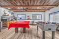 Your game room awaits with pool table and foosball under stunning reclaimed wood beams—perfect for friendly competition and memorable evenings.