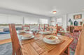Gather around your nautical-themed dining table where morning coffee and evening meals become memorable moments with stunning water views.