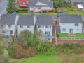 Aerial view of modern townhomes in a peaceful residential neighborhood with lush green spaces and convenient parking.