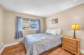 Sink into crisp white linens in your peaceful bedroom, where warm wood floors and gentle natural light create the perfect retreat.