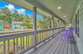 Unwind on your private covered porch with charming purple Adirondack chairs, perfect for morning coffee or evening relaxation.