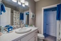 Step into your well-appointed bathroom featuring modern fixtures, elegant lighting, and thoughtful coastal-themed touches in soothing blue accents.