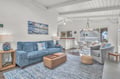 Unwind in your bright, open living space with coastal charm—exposed beams, ocean artwork, and comfortable seating create the perfect retreat.