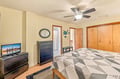 Unwind in your cozy bedroom with a comfy bed, ceiling fan, and ample storage space. Your private retreat features warm wood tones, decor touches, and everything you need for a restful stay.