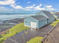 Charming oceanfront home sits steps from dramatic waves crashing against rocky coastline.