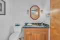 Step into your elegantly appointed bathroom featuring warm wood cabinetry and sophisticated granite countertops for a luxurious daily routine.