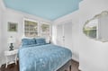 Drift off peacefully in your serene bedroom featuring soft blue linens and charming coastal touches throughout.