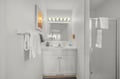 Your bright, clean bathroom features fresh white towels, Hollywood-style vanity lighting, and a spacious walk-in shower—all the comforts you need to feel refreshed.
