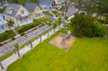 Aerial view showcasing a charming residential neighborhood with colorful beach houses, community playground, and lush green spaces.