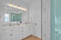 Step into your spa-like bathroom with dual vanities, elegant pendant lighting, and a stunning aqua-tiled shower that invites relaxation.