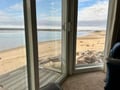Step onto your private deck and take in the stunning beachfront vista stretching before you—sand, sea, and sky frame your peaceful coastal retreat.