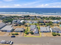 Aerial view of a beachside property located just moments from the sandy shore, nestled within a charming coastal neighborhood with direct beach access nearby.