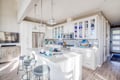 Your gourmet kitchen features pristine white cabinets, quartz countertops, and a spacious island perfect for morning coffee or culinary adventures.