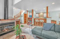 Settle into your cozy open-concept living space with warm fireplace, breakfast bar, and natural light streaming through.