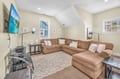 Sink into this spacious sectional sofa for your favorite shows on the large TV, with natural light streaming through windows.