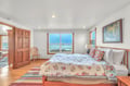 Wake to ocean waves outside your window in this cozy bedroom with warm wood details and charming floral bedding.