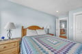 Drift into peaceful sleep in your cozy bedroom with soft blue walls and charming wood furnishings.