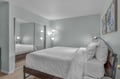 Sink into crisp white linens in your peaceful bedroom, where soft lighting and calming mint walls create the perfect retreat after exploring.
