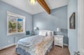 Drift off peacefully in your cozy bedroom with exposed wood beams and soothing blue walls that create the perfect coastal retreat.