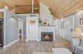 Unwind in this cozy open-concept space where soaring wood-beam ceilings and a crackling fireplace create your perfect retreat. Settle into the warm ambiance as natural light fills your home away from home.