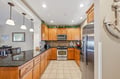 Your fully equipped kitchen invites you to cook and gather, with rich wood cabinetry, granite counters, stainless steel appliances, and a breakfast bar ready for morning coffee or evening conversation.