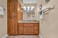 Your spacious bathroom features rich wood cabinetry, granite countertops, and ample storage for all your essentials during your stay.