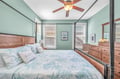 Relax in your tranquil bedroom with soothing coastal colors, comfortable four-poster bed, and warm wood furnishings creating the perfect retreat.