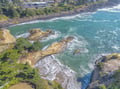 Dramatic coastal landscape features rugged cliffs, turquoise waters, and sandy rock formations along this stunning oceanfront location.