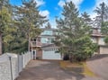Charming coastal home nestled among towering evergreens with convenient garage parking and private driveway access.