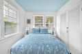 Drift off in this serene bedroom where soft blue linens and a painted ceiling create your personal oasis of calm.