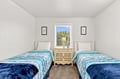 Settle into your serene twin bedroom with plush bedding and natural light streaming through the window. Rest easy knowing you have a peaceful retreat after a day of adventure.