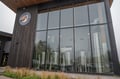 Pelican Brewing's entrance showcases a modern facade with floor-to-ceiling windows revealing the brewing operation inside.