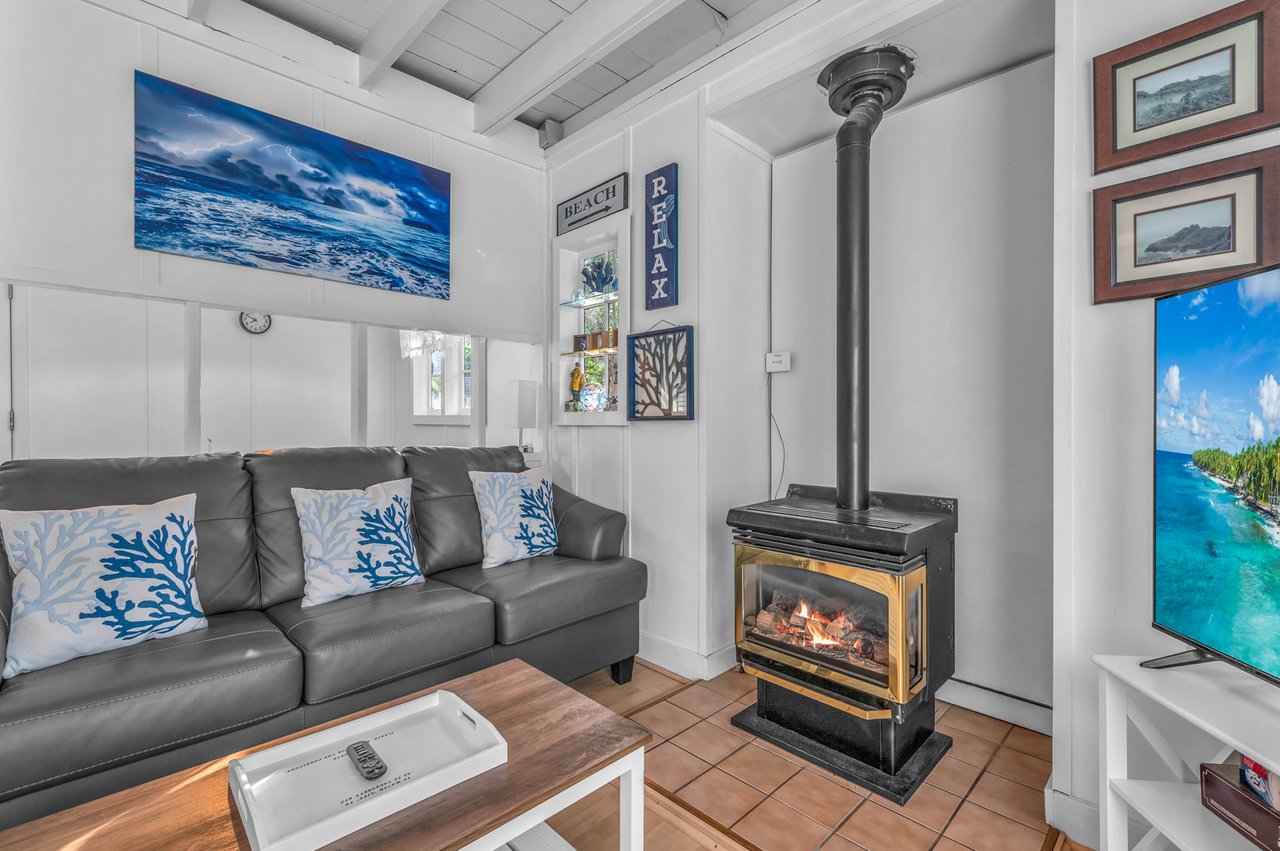 Cozy up by your private fireplace in this charming cottage living room, complete with ocean-themed artwork.