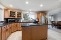 Cook with ease in this spacious kitchen featuring warm wood cabinets, granite counters, and stainless steel appliances perfect for your getaway.